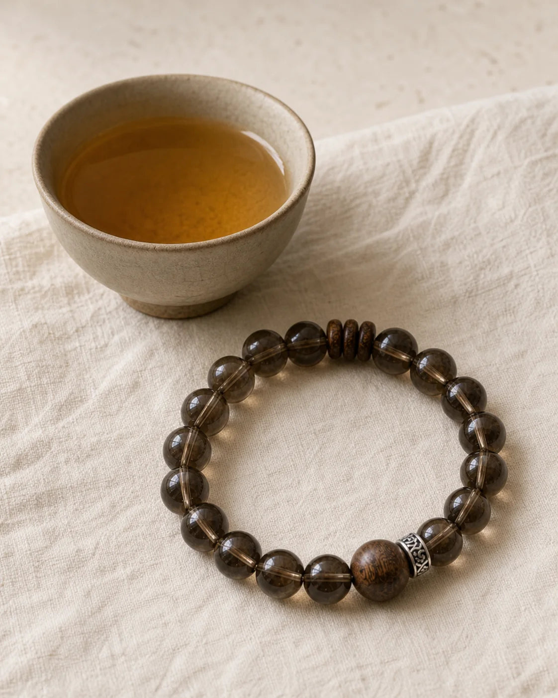 Aged Shou Mei bracelet beside a tea cup