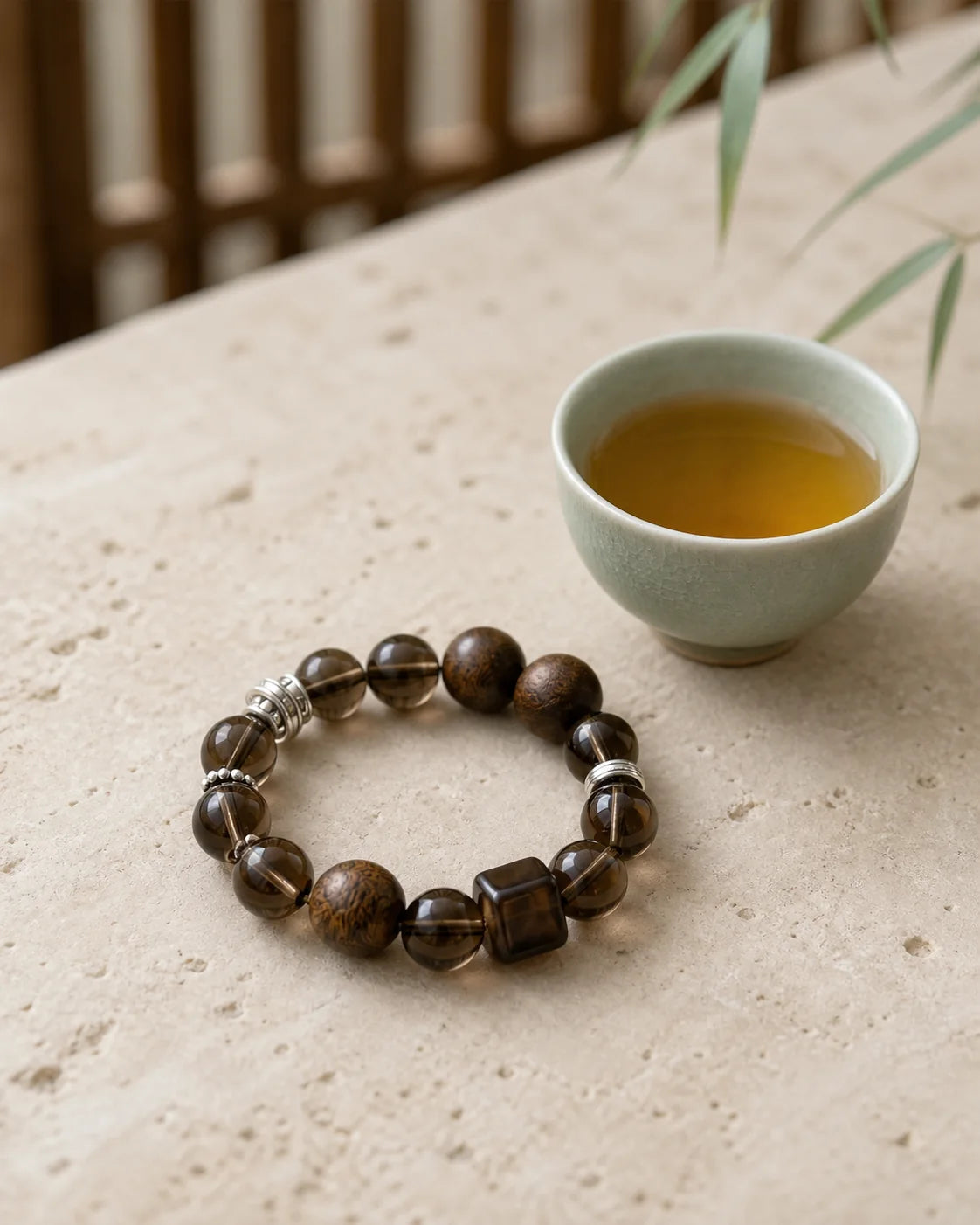 Ancient Tree Sheng Pu’er bracelet beside a tea cup
