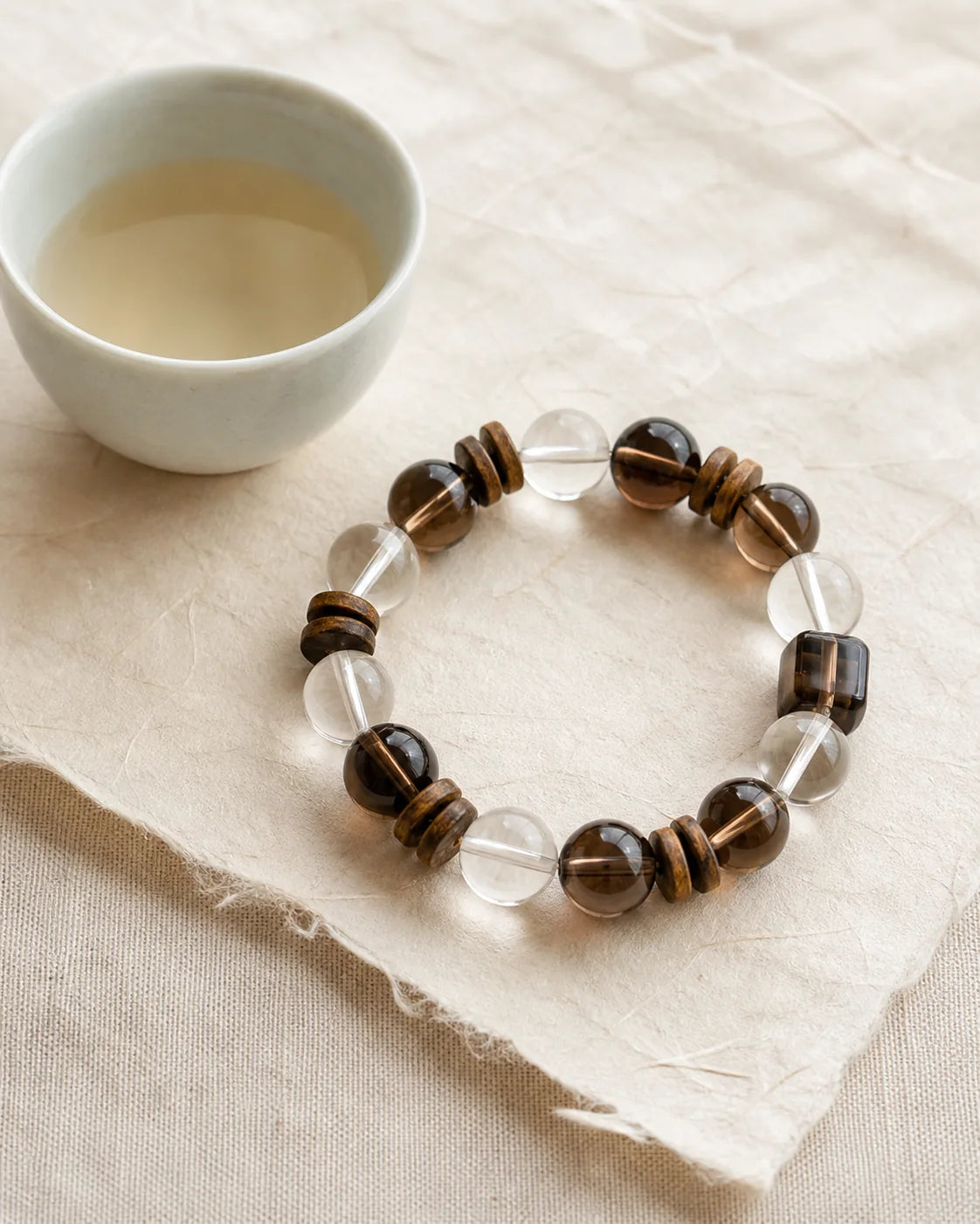 Clear White Tea bracelet beside a tea cup