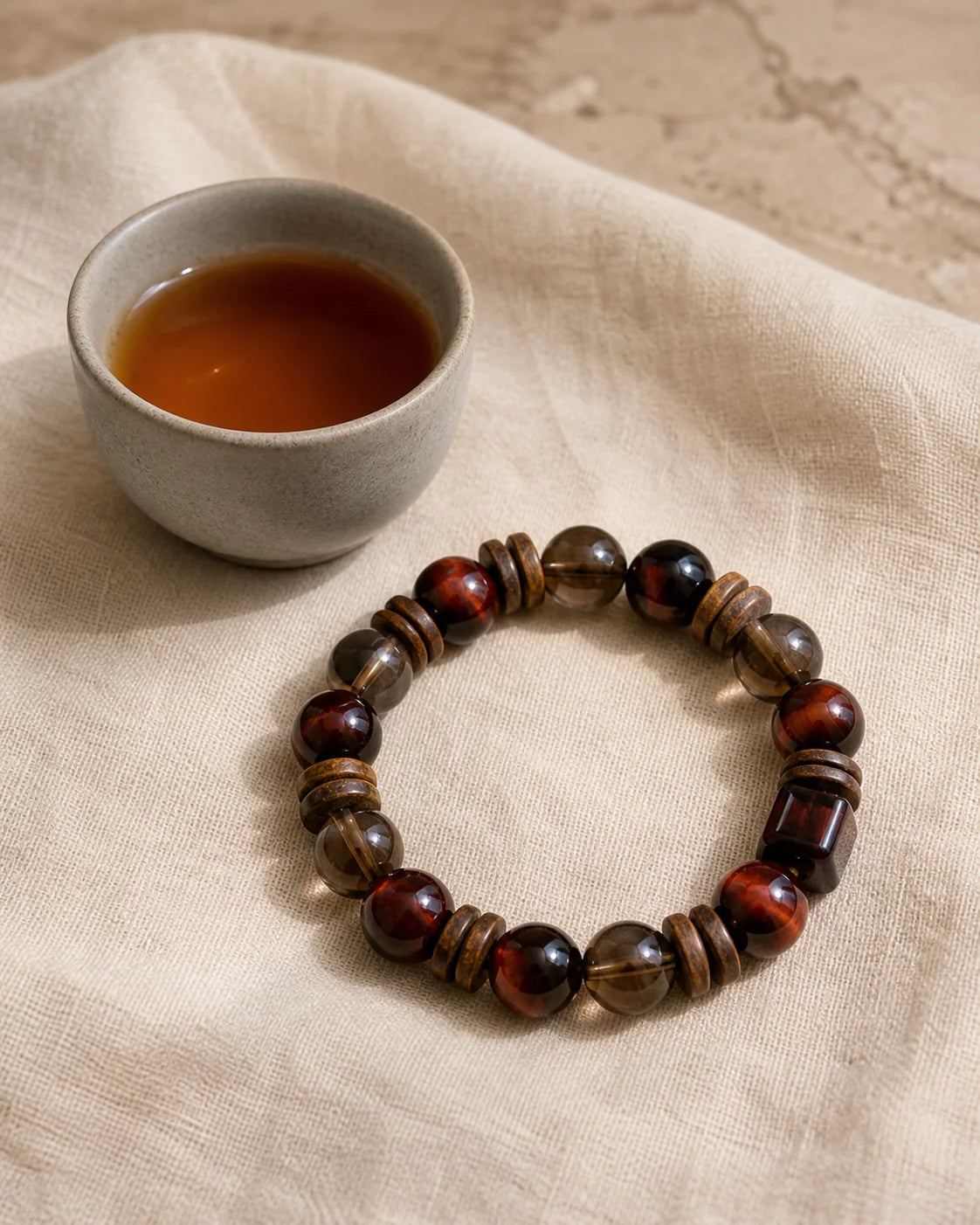 Dan Yan Da Hong Pao bracelet beside a tea cup