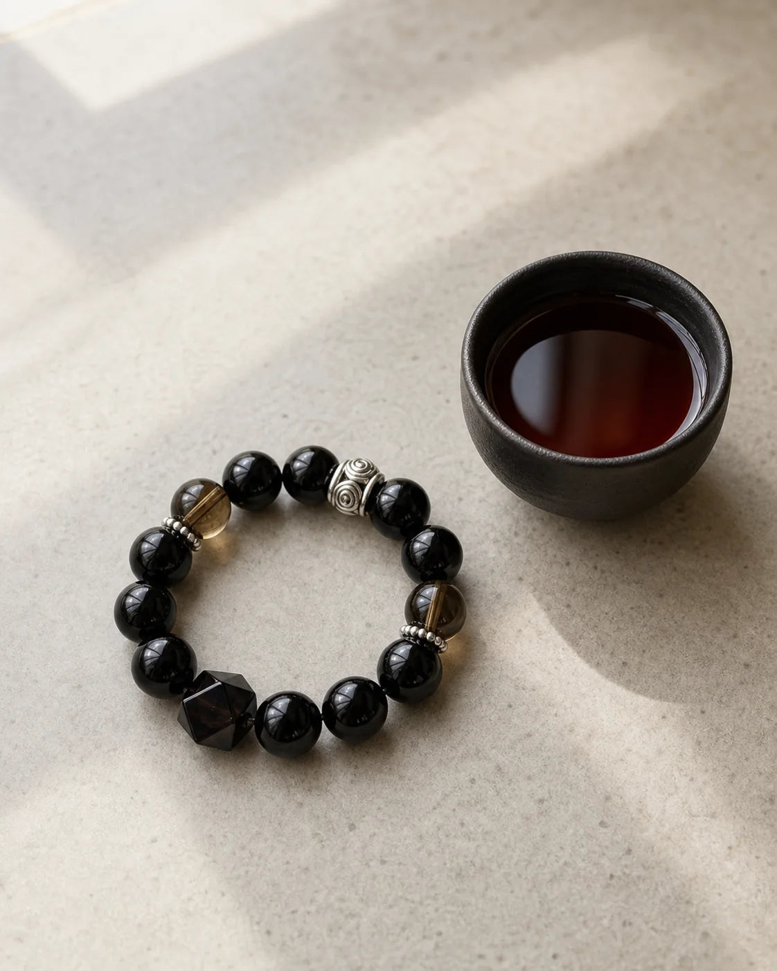 Ink Fu Tea bracelet beside a tea cup