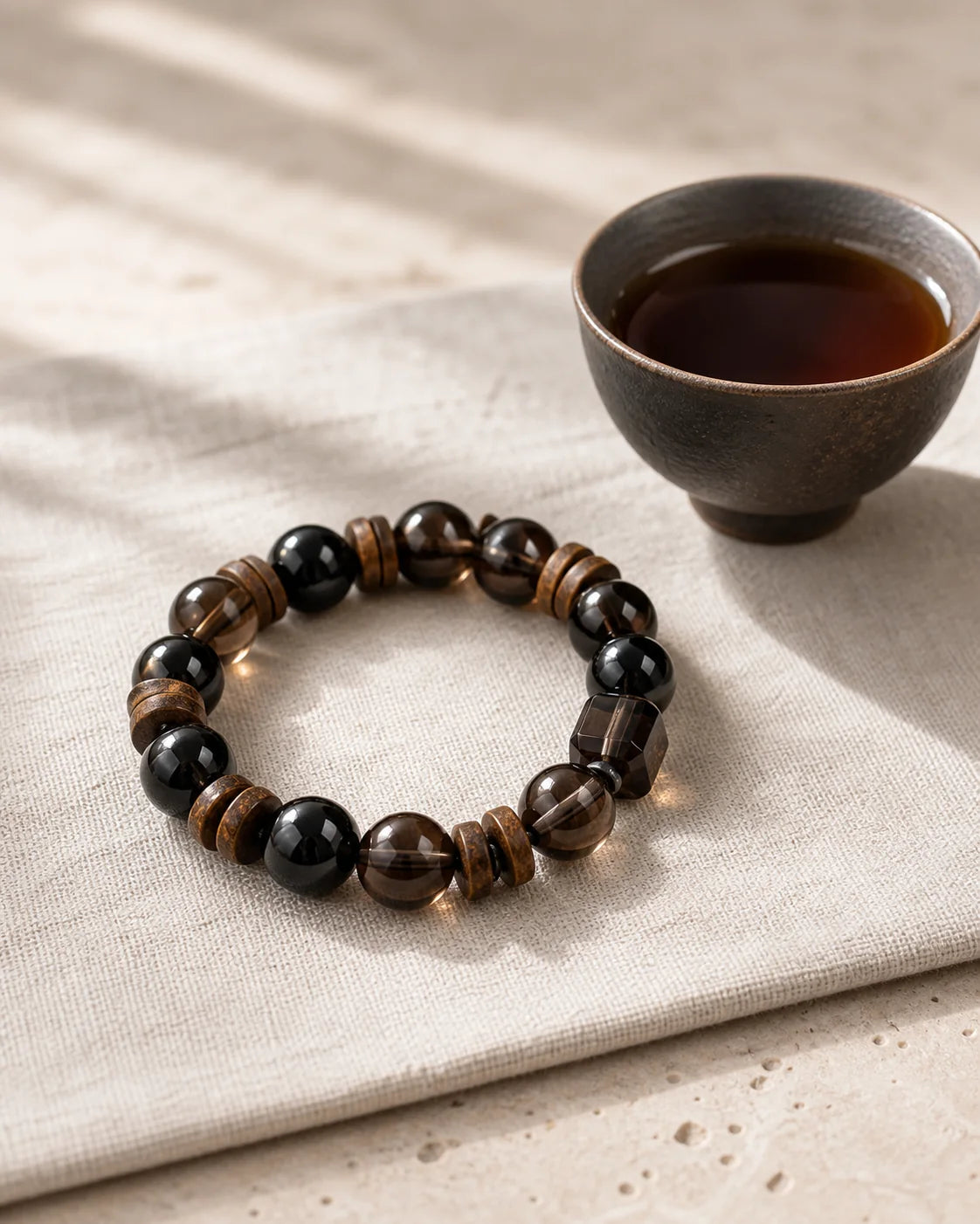 Ripe Pu’er bracelet beside a tea cup