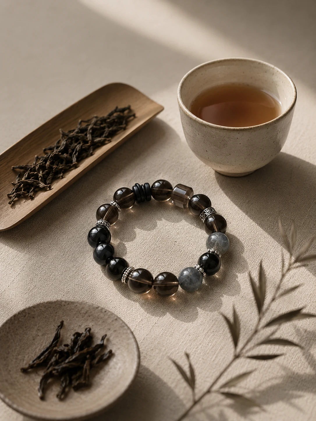 Dark crystal bracelet beside tea in late morning light